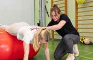 Fysiotherapeut Helpt Patiënt Met Oefening Op Een Bal