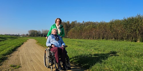 Medewerker Rivas Loopt Buiten Met Clënt In Rolstoel