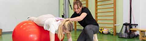 Fysiotherapeut Helpt Patiënt Met Oefening Op Een Bal