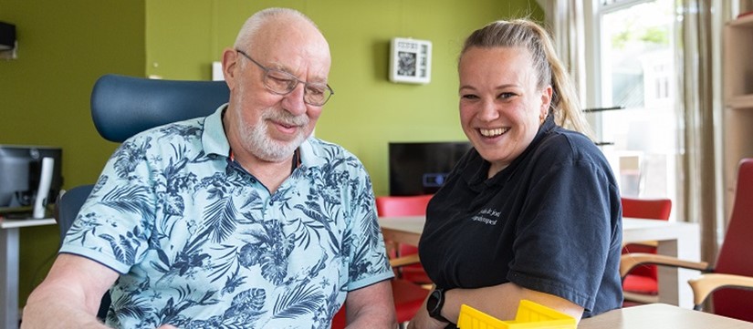 Meneer doet samen met medewerker Revalidatie een spel aan tafel