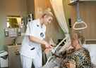 Verpleegkundige Helpt Patiënt Die In Bed Ligt