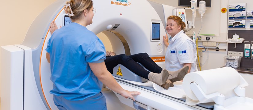 Patiënt in CT-scanner met twee verpleegkundige